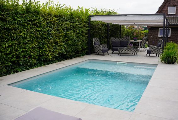 Kleinster Pool umgeben von Pflanzen, mit einer sitzenden Lounge-Area.